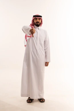 رجل سعودي بالثوب التقليدي يشير بعلامة الرفض