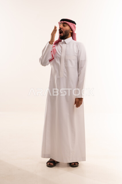 رجل سعودي يتثاءب بالثوب التقليدي في الاستوديو