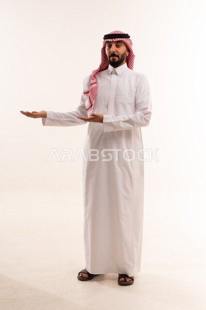 Saudi Man in Traditional Thobe Pointing on White Background