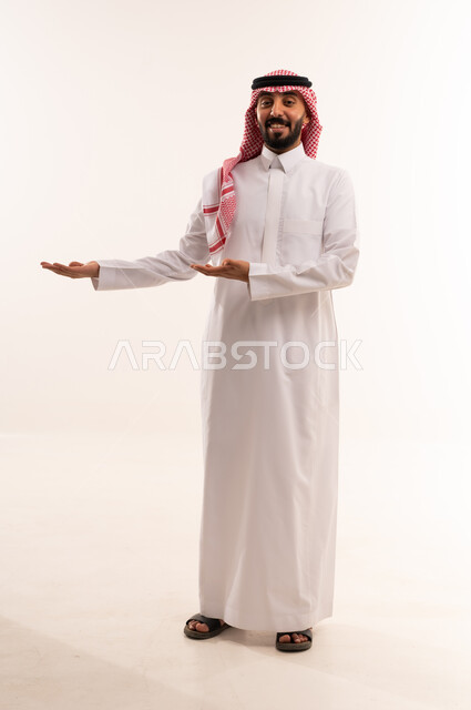 رجل سعودي بالزي التقليدي يشير على خلفية بيضاء