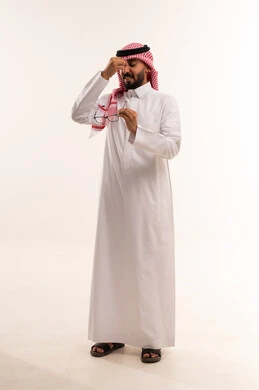 Saudi Man in Traditional Thobe Holding Glasses