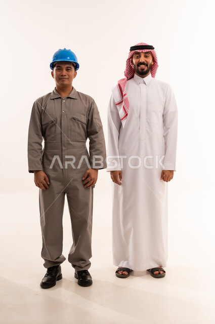 رجل أعمال سعودي وعامل آسيوي بزي العمل في الاستوديو