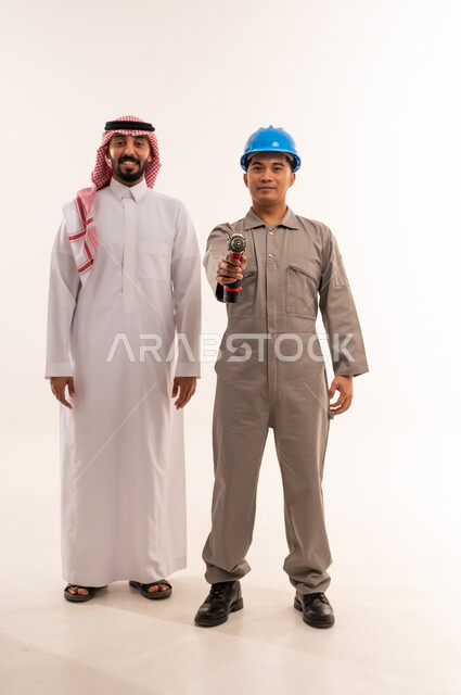 رجل أعمال سعودي وفني مع مثقاب كهربائي