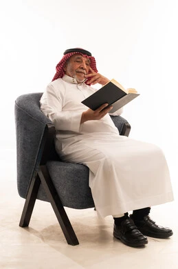 Senior Saudi Man Reading Book in Armchair
