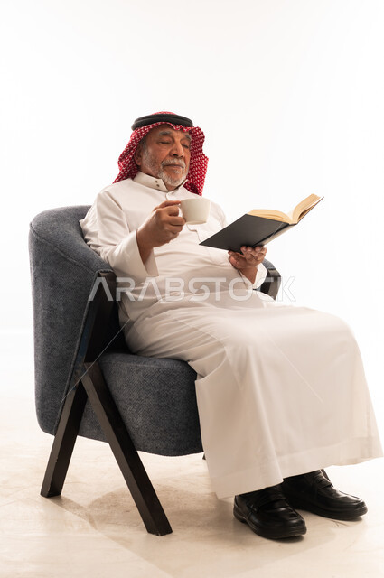 Elderly Saudi Man Reading Book in Traditional Thobe