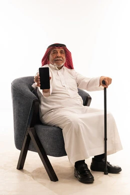 Saudi Senior Man Holding Smartphone in Traditional Thobe