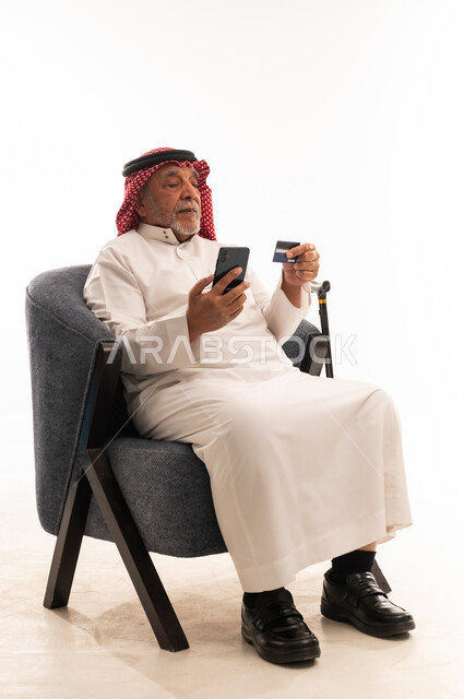 رجل سعودي مسن يتسوق إلكترونياً ببطاقة ائتمان