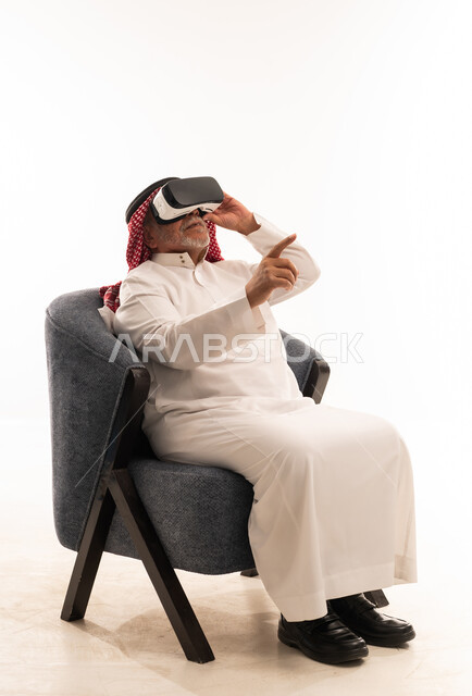 رجل سعودي يرتدي نظارة واقع افتراضي بخلفية بيضاء