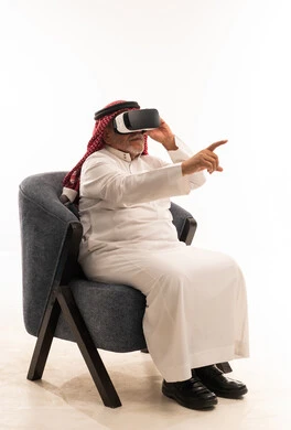 Elderly Saudi Man Using VR Headset in Armchair