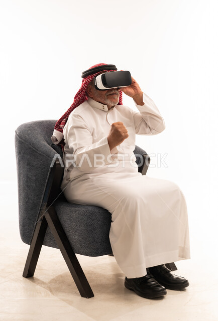 Elderly Saudi Man Using VR Headset in Traditional Dress