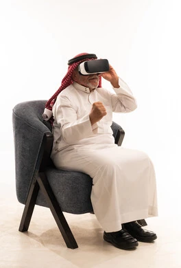 Elderly Saudi Man Using VR Headset in Traditional Dress