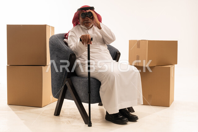 Elderly Saudi Man with Binoculars and Moving Boxes