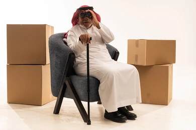 Elderly Saudi Man with Binoculars and Moving Boxes