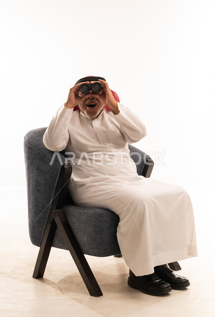 رجل سعودي مسن يستخدم المنظار في الاستوديو