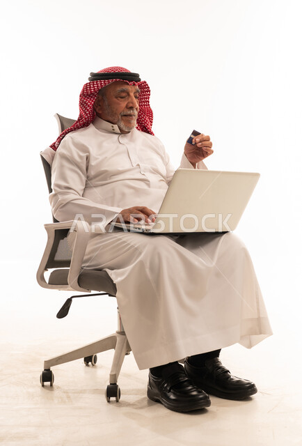 رجل سعودي مسن يستخدم المحمول والبطاقة البنكية
