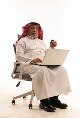 Elderly Saudi Man Using Laptop and Credit Card in Studio