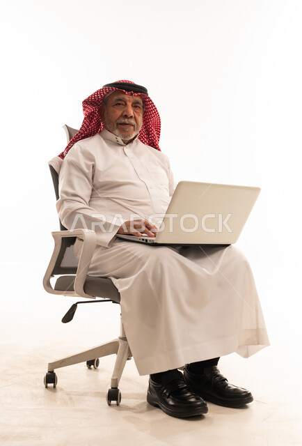 رجل سعودي مسن يستخدم المحمول بالزي التقليدي