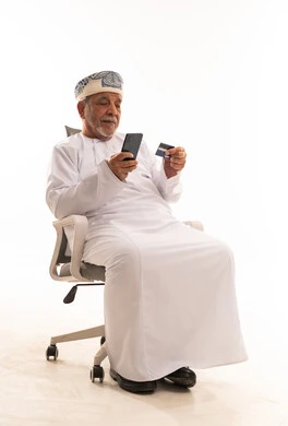 Senior Omani Man Using Smartphone and Credit Card