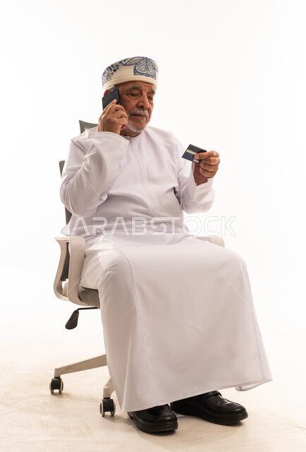 رجل عماني مسن يستخدم بطاقة الائتمان والهاتف