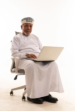 Elderly Omani Man Using Laptop in Studio