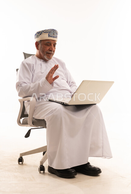 Elderly Omani Man Using Laptop on White Background