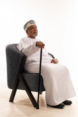 Elderly Omani Man in Traditional Dress with Walking Cane