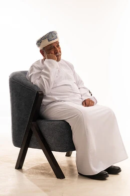 رجل عماني مسن بالزي التقليدي على خلفية بيضاء