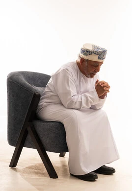 Elderly Omani Man in Traditional Dress on Armchair
