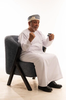 Omani Senior Man Celebrating with Credit Card in Studio