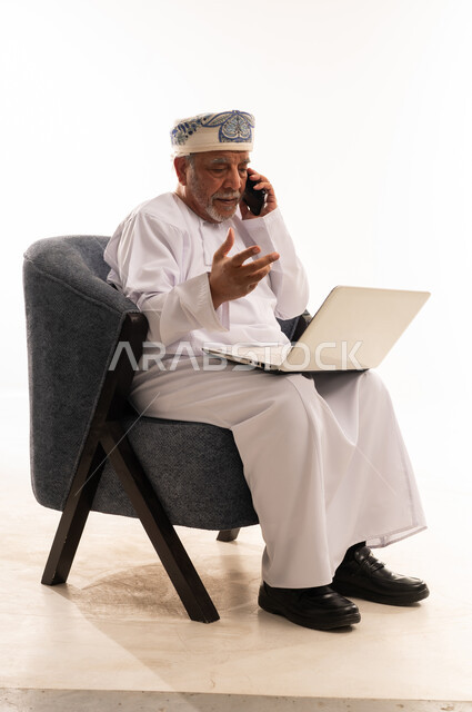 رجل عماني مسن يستخدم المحمول والهاتف في الاستوديو