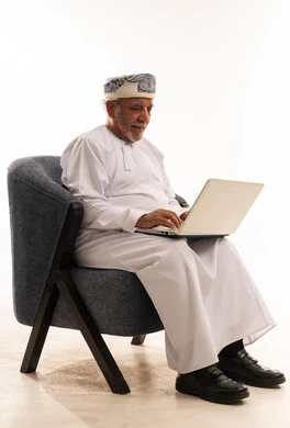 رجل عماني مسن يستخدم المحمول بالزي التقليدي