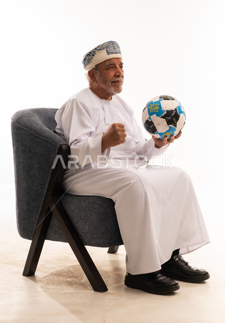 رجل عماني مسن مع كرة قدم يحتفل