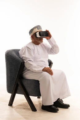 رجل عماني مسن يرتدي نظارة واقع افتراضي في استوديو