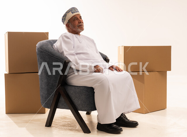 Elderly Omani Man with Moving Boxes in Studio