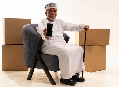 Omani Senior Man with Smartphone and Shipping Boxes