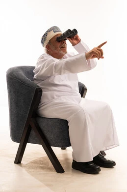 Elderly Omani Man with Binoculars in Traditional Dress