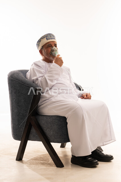 رجل عماني مسن يستخدم جهاز التنفس في الاستوديو