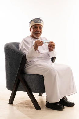 رجل عُماني مسن يحمل شريط أدوية في الاستوديو