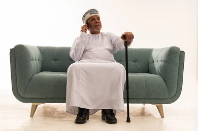Elderly Omani Man on Phone with Walking Stick