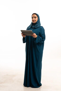 امرأة عربية بعباءة زرقاء تمسك جهاز لوحي رقمي