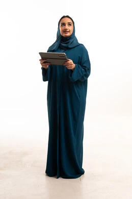امرأة إماراتية بالعباءة مع جهاز لوحي بخلفية بيضاء