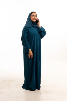 امرأة سعودية بالعباءة تتحدث بالهاتف في استوديو