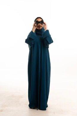 امرأة سعودية بالعباءة تنظر من خلال المنظار