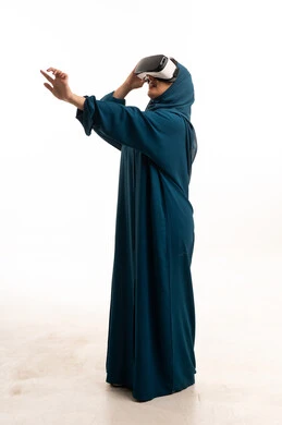 امرأة سعودية بالعباءة تستخدم نظارة الواقع الافتراضي