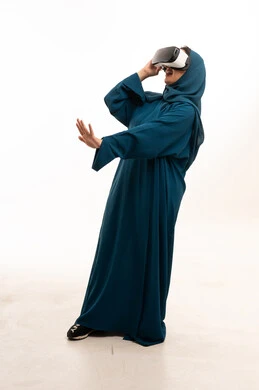 امرأة سعودية ترتدي العباءة تستخدم نظارة الواقع الافتراضي