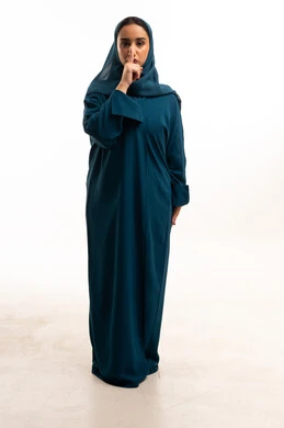 Emirati Woman in Teal Abaya Making Silence Gesture