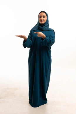 امرأة إماراتية بعباءة خضراء تشير بيدها