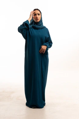 امرأة سعودية بالعباءة تعاني من صداع في الاستوديو