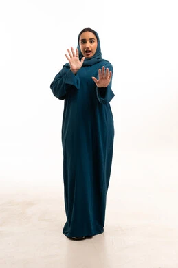 امرأة سعودية بالعباءة تقوم بإشارة التوقف