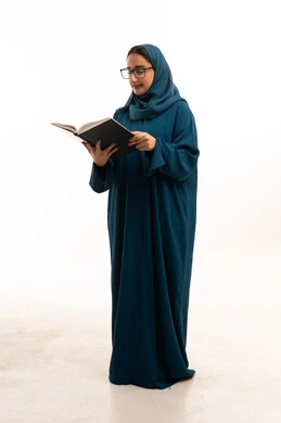امرأة سعودية تقرأ كتاباً بالعباءة والنظارات